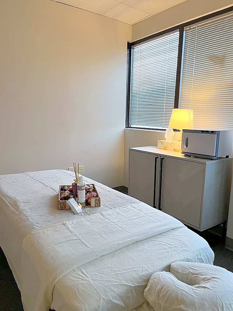 Private massage room with fresh linens and warm lamp light